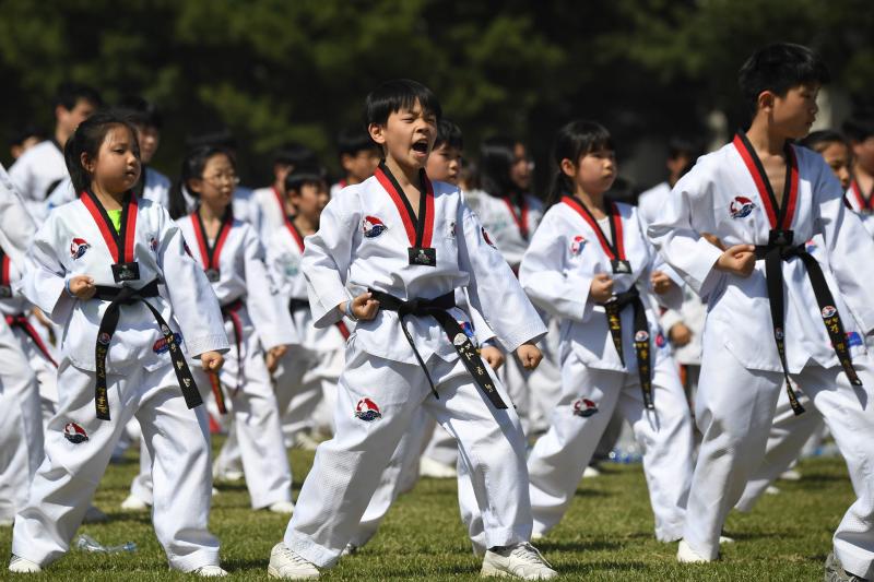 Diez mil deportistas de Taekwondo participan en una exhibición, delante del edificio de la Asamblea Nacional de Corea del Sur, en Seúl, para celebrar la declaración de este arte marcial como deporte oficial patrocinado por el Estado y para intentar marcar un nuevo récord Guinness de participantes. 