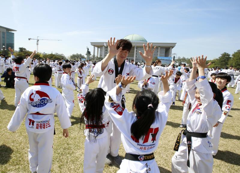 Diez mil deportistas de Taekwondo participan en una exhibición, delante del edificio de la Asamblea Nacional de Corea del Sur, en Seúl, para celebrar la declaración de este arte marcial como deporte oficial patrocinado por el Estado y para intentar marcar un nuevo récord Guinness de participantes. 