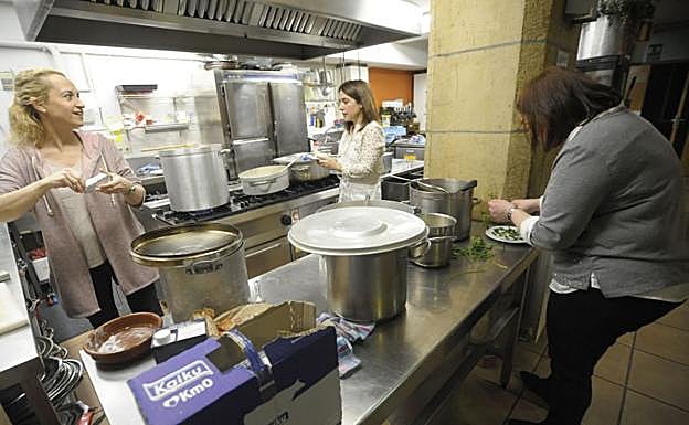 Una de las voluntarias de CaixaBank sirve la comida a la cerca de una veintena de invitados. 