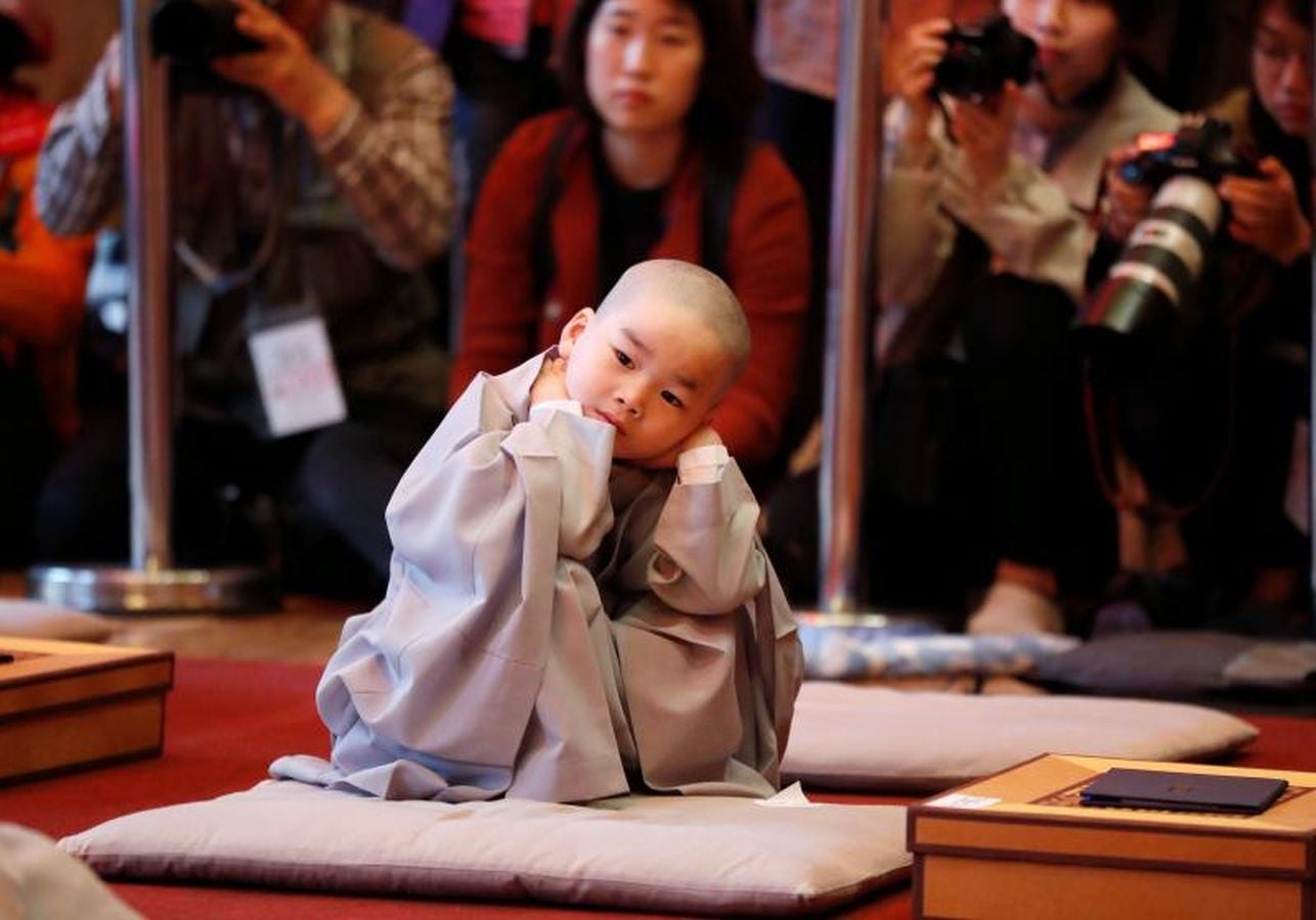 Los monjes principiantes caminan bajo linternas de loto con peticiones de oración cuando se van después de un evento para celebrar el próximo Día de Vesak, el cumpleaños de Buda, en el templo Jogye en Seúl, Corea del Sur, 2 de mayo de 2018.