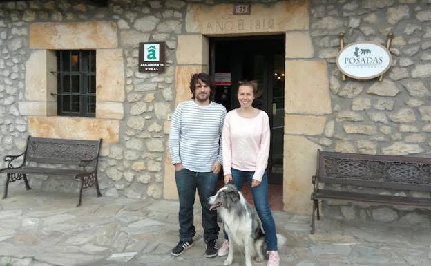 Roberto y Naiara, junto a su perro Urra, en la entrada principal de la Posada Alfonso.