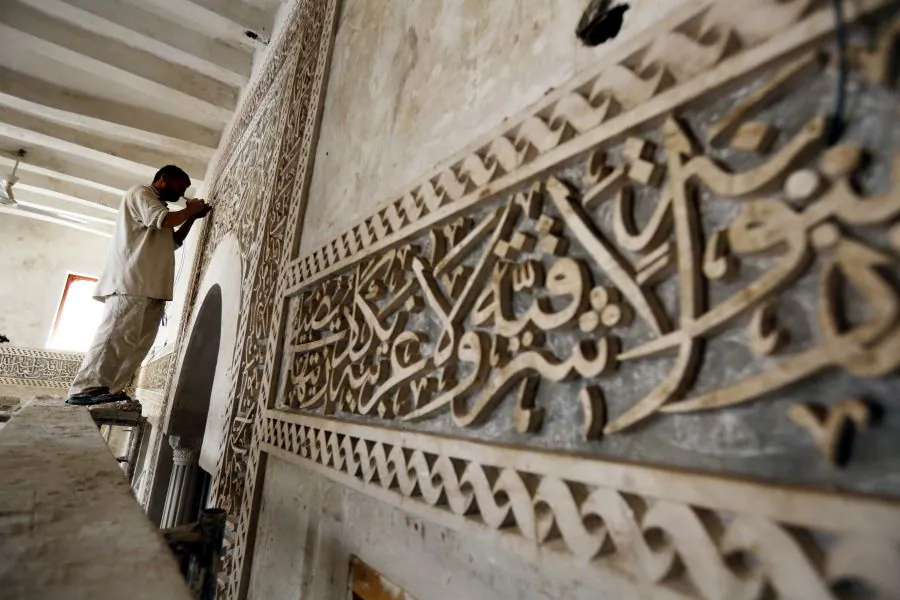 Un trabajador yemení realiza labores de restauración en una mezquita antes del Ramadán, en el casco antiguo de Saná (Yemen). 