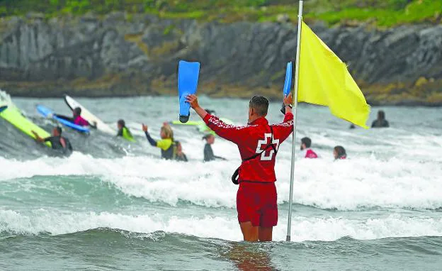 Un socorrista de Cruz Roja hace señales junto a la zona reservada a los surfistas. 