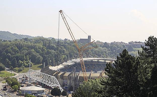 Vista aérea de los trabajos del estadio de Anoeta, este jueves, con la cercha lista para ser izada sobre los pilares por la grúa desplegada a la derecha. 