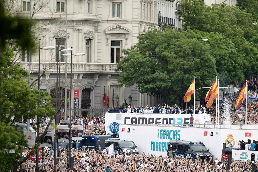 La comitiva blanca, con Florentino Pérez al frente, paseó la 'decimotercera' por las calles de la capital y festejó el título con los miles de aficionados que se reunieron en la fuente de Cibeles 