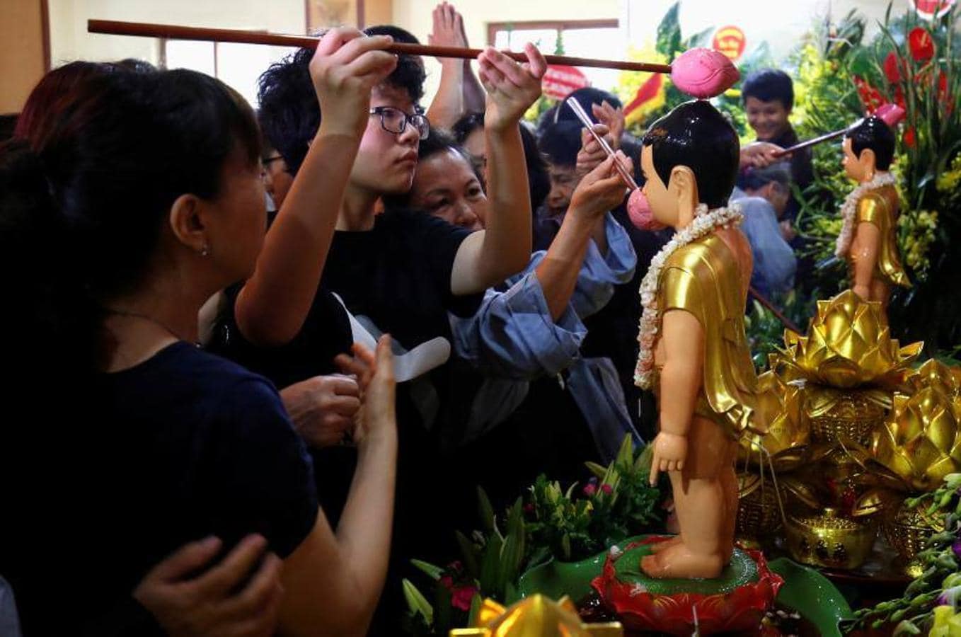 Los vietnamitas budistas vierten agua perfumada mientras bañan estatuas del niño Buda durante las celebraciones del 'VosakÊDay' que conmemora el nacimiento, la iluminación y el ingreso del Buda al Nirvana en la pagoda Quan Su, en Hanoi, Vietnam. 