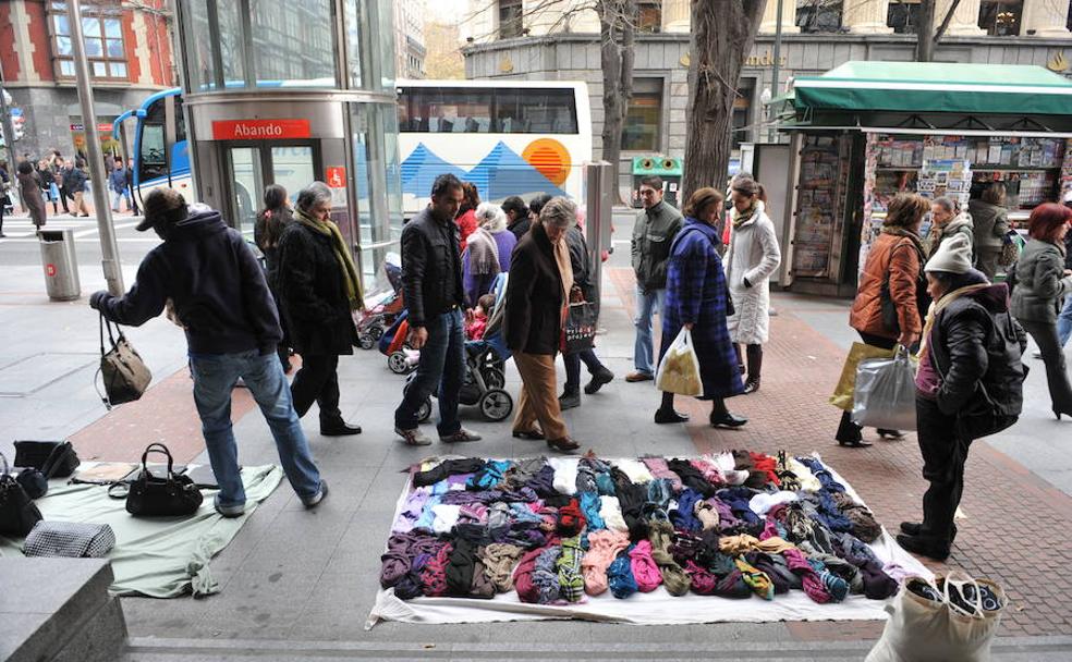 Manteros exponen su género en la Gran Vía de Bilbao.