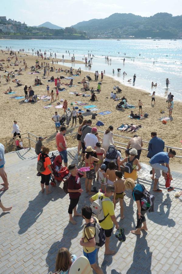 Los donostiarras han aprovechado los rayos de sol de la jornada para pasear por la playa