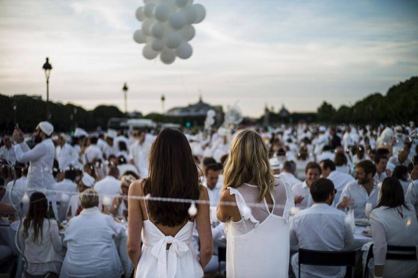 Miles de personas vestidas de blanco comparten una cena en Inválidos durante la 30ª edición de la cena en blanco 'Diner en Blanc' en París.