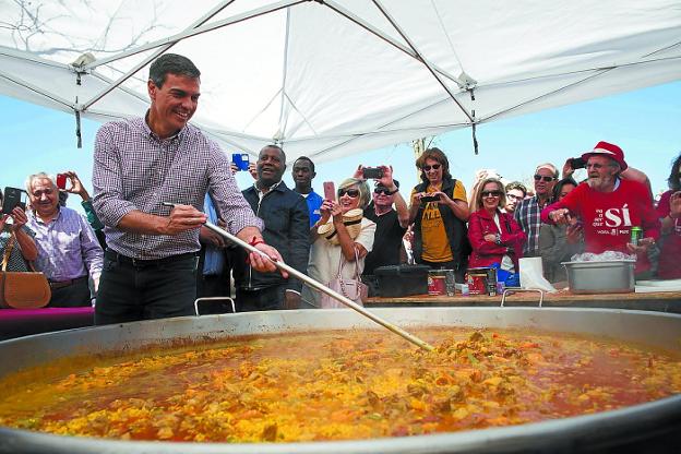 Sánchez prepara una paella junto a un grupo de militantes en un acto de las últimas primarias.