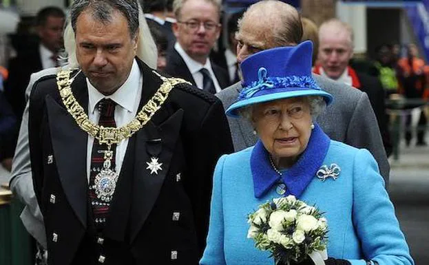 La reina Isabel II camina con Lord Lieutenant y Lord Provost. 
