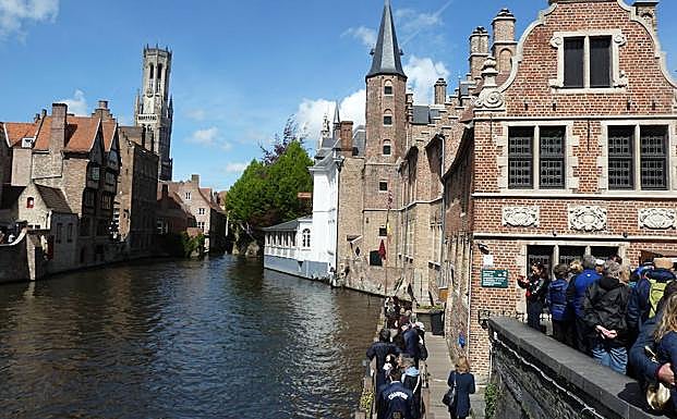 Imagen principal - En la imagen superior, la esquina célebre de Brujas, un canto a la belleza. Debajo, centro monumental de Lovaina y Gante.