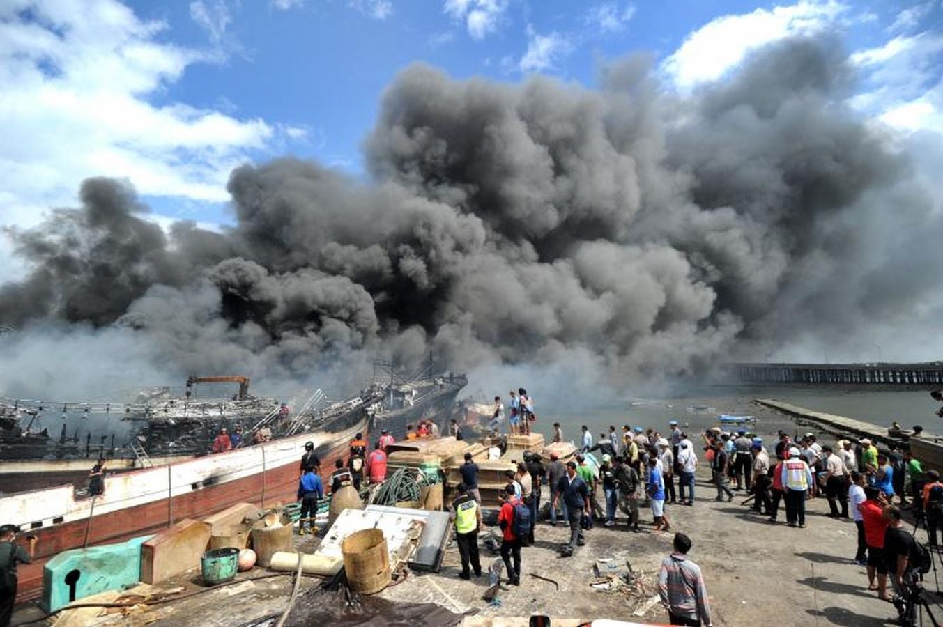 Varios bomberos trabajan en la extinción de un incendio de un barco en el puerto de Benoa, en Bali (Indonesia).