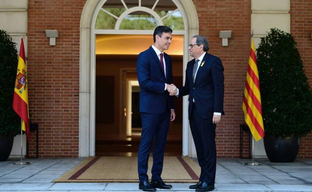 El presidente del Gobierno, Pedro Sánchez, saluda al president de la Generalitat, Quim Torra, en la escalinata del palacio de la Moncloa.