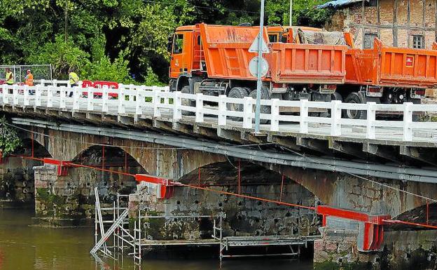 Dos camiones participan en la prueba de carga del puente de Astiñene, cuya estructura ha sido reforzada para soportar el paso de coches y autobuses. 