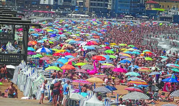 Playa a rebosar. Aspecto de la playa con miles de personas a lo largo y ancho del arenal. 