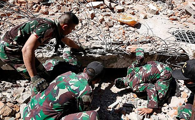 Soldados buscan supervivientes entre los escombros.