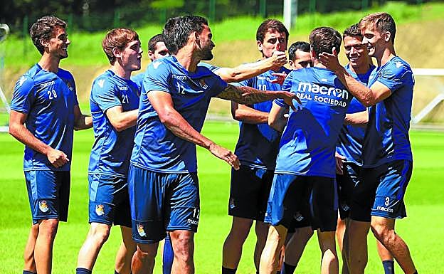 Los jugadores de la Real Sociedad bromean antes del comienzo del entrenamiento ayer en Zubieta. 