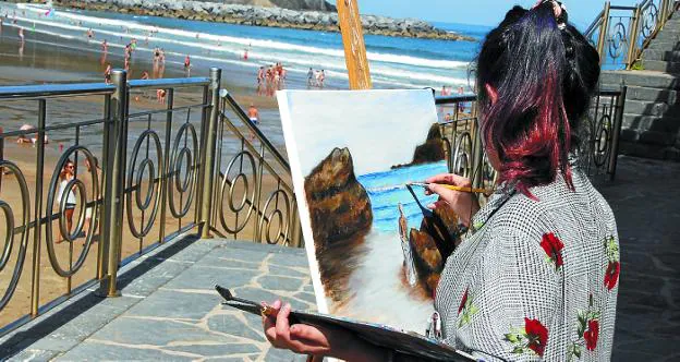 Una de las participantes, elaborando su trabajo frente a la playa. 