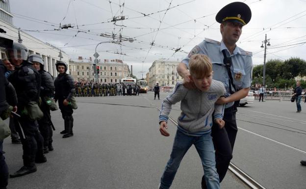 Un agente se lleva a un menor de la manifestación en San Petersburgo. 