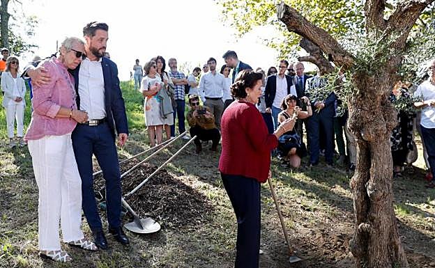 Dolores García (2i), y José Miguel Cedillo (i), viuda e hijo del policía nacional asesinado por ETA el 14 de septiembre de 1982, y la hermana del fallecido, María Cedillo, observan un olivo plantado en Errenteria. 