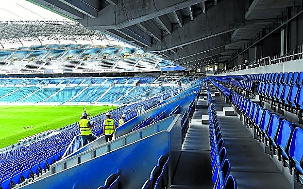 Varios operarios, en la Tribuna Sur de Anoeta el viernes. Los trabajos en el estadio siguen a buen ritmo y mañana se notarán mejoras en la instalación.