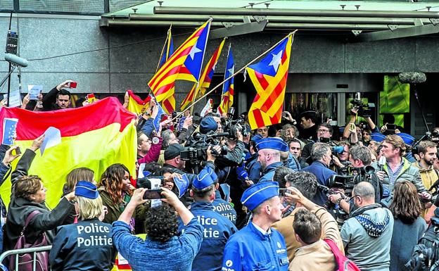 Manifestantes con banderas españolas y esteladas se enzarzan a la puerta del Club de la Prensa de Bruselas durante una comparecencia de Puigdemont. 