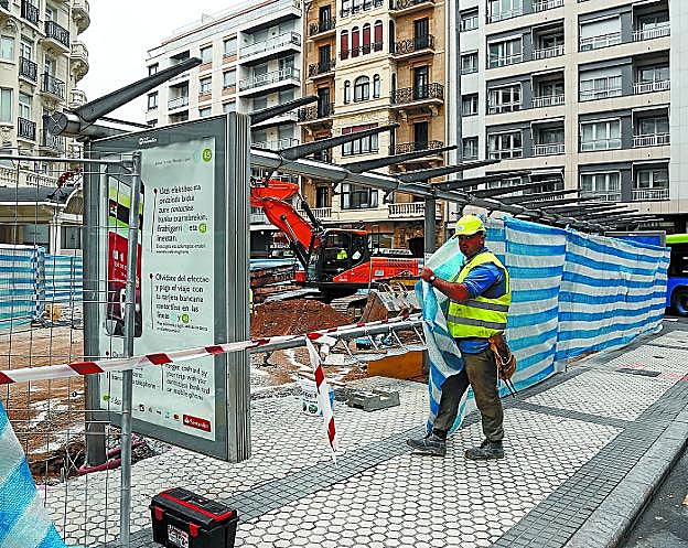 Un operario precinta la marquesina del autobús para las obras del Metro en la plaza Xabier Zubiri. 