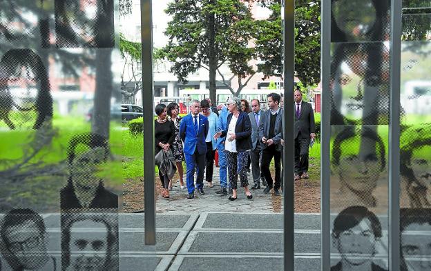 Visita. Urkullu y el resto de la delegación vasca accede al ESMA, en cuyas puertas se reproducen retratos de torturados.