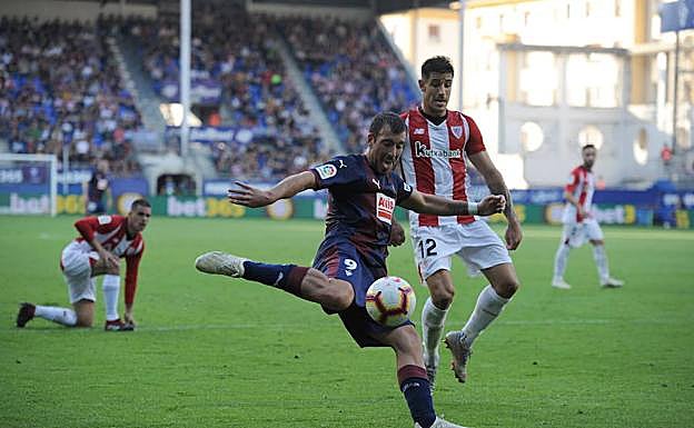 Sergi Enrich se dispone a centrar ante la oposición del rojiblanco Yuri Berchiche. 