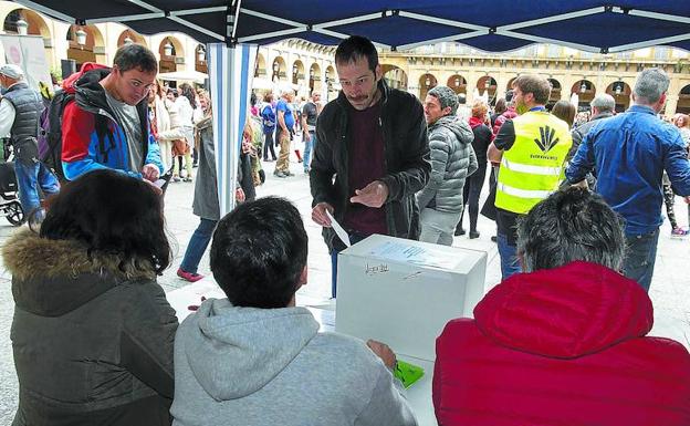 Un joven se dispone a votar en una de las urnas instaladas por Gure Esku Dago en la plaza de la Constitución de San Sebastián. 