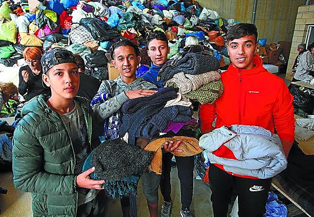 Adolescentes extranjeros acogidos en Uba, muy activos en la clasificación de la ropa recogida el fin de semana.