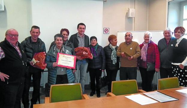 Vecinos, los ganadores de los dos jamones y los representantes de Agifes y del Ayuntamiento. 