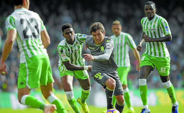 Mikel Oyarzabal intenta avanzar sobre la portería de Pau López rodeado de jugadores béticos. 