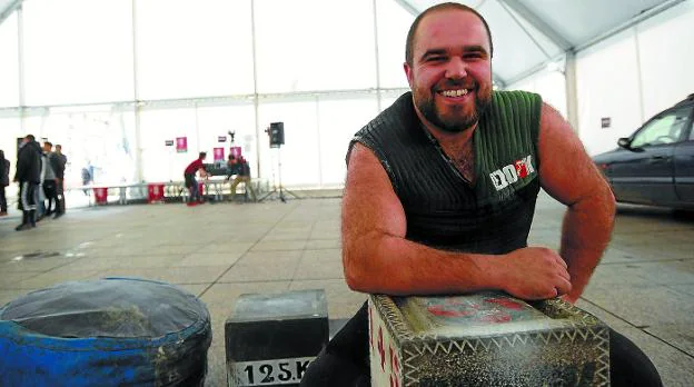 Iñigo Jiménez busca apoyos para levantar la piedra de los 200 kilos, de cara a superar récords, en una plaza de Eibar.