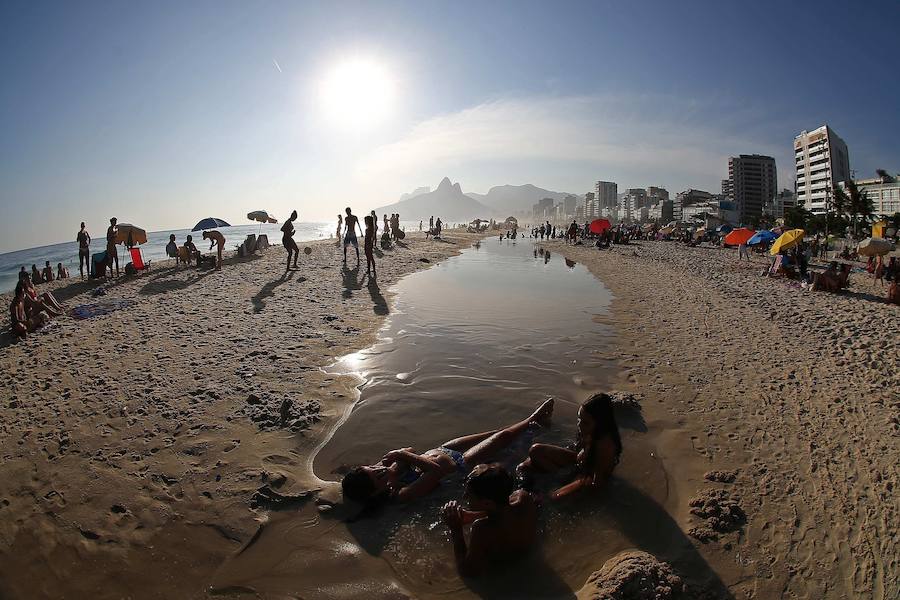 Ya ha comenzado ell verano austral. Pero las playas de Río de Janeiro ya están llenas de bañistas desde hace unas semanas. Y es que el calor aprieta. El martes los termómetros alcanzaron 40,7 grados en la zona oeste de la ciudad, en el que ha sido el día más caluroso en varios años, con una sensación térmica de 45 grados. El mar está calmado y apenas hay olas en las transparentes aguas. Las imágenes han sido tomadas en la Floresta de Tijuca, el bosque urbano más grande del mundo, y en los arenales del oeste de Río.