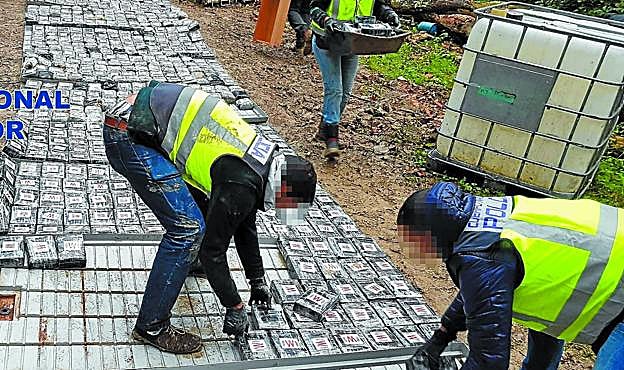 Policías manipulan los paquetes de cocaína que fueron localizados en Zarautz. 