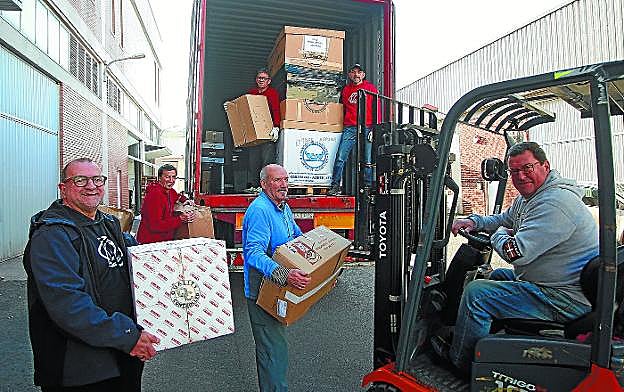 Los voluntarios llevan las cajas hasta el último camión cargado ayer en el almacén de Martutene.