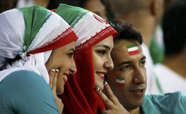 Dos mujeres y un hombre se fotografían en los prolegómenos de un partido de la Copa de Asia. 