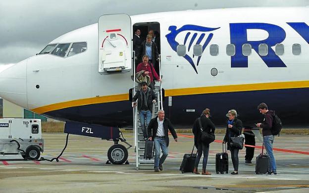 Un grupo de pasajeros desciende de un avión de Ryanair. 