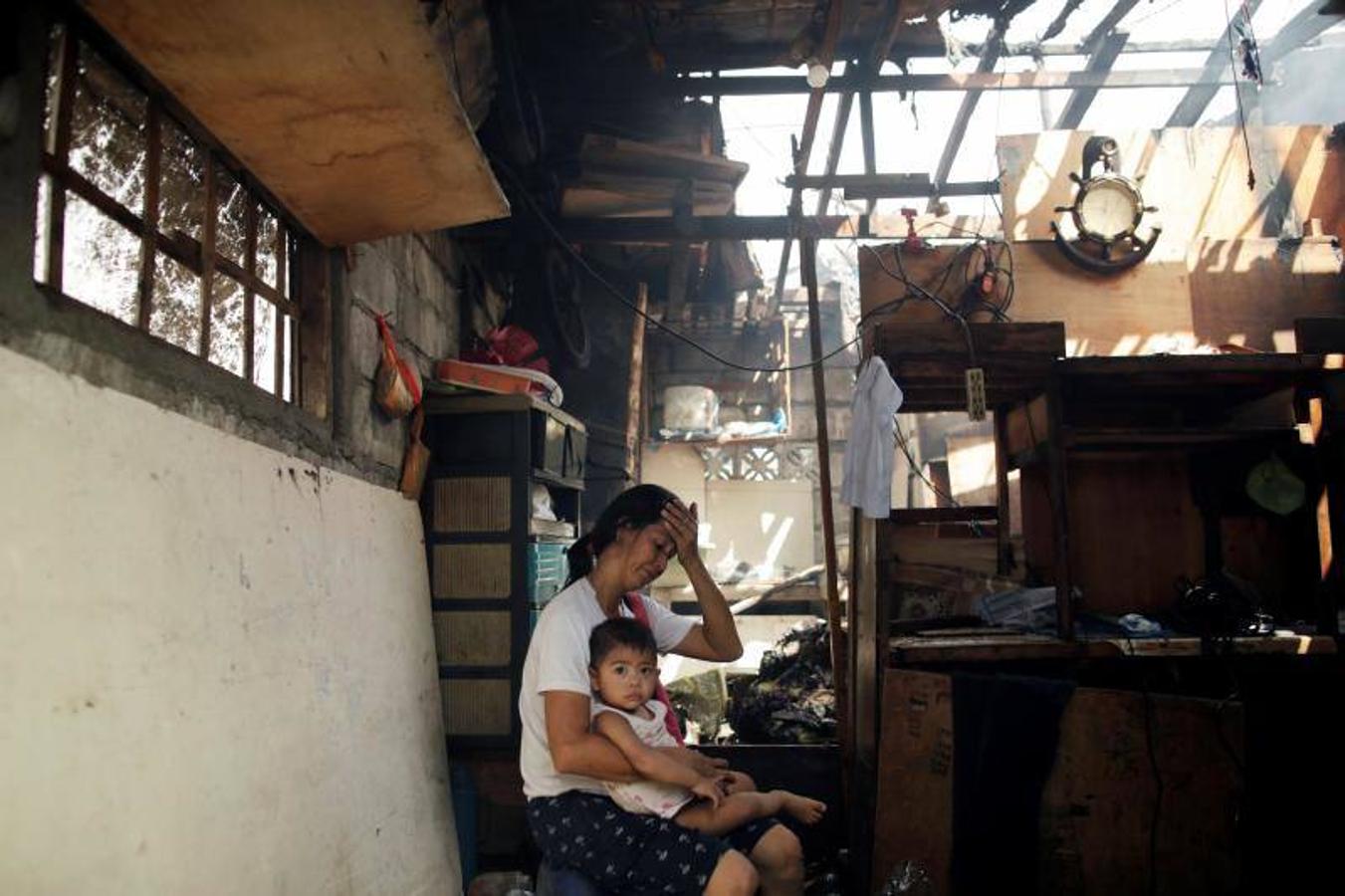 Residentes se afanan por apagar las llamas durante el incendio originado en un barrio de chabolas de Manila, en Filipinas, hoy, 11 de enero de 2019. El incendio destrozó las viviendas de al menos 100 familias pobres.