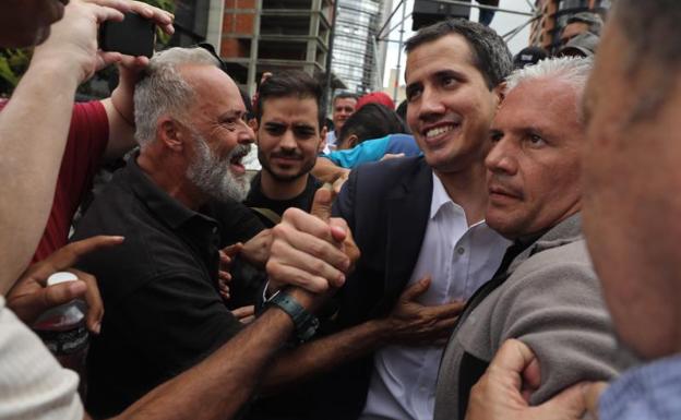El presidente del Parlamento venezolano, Juan Guaidó (c), saluda a los simpatizantes tras autoproclamarse presidente del país.