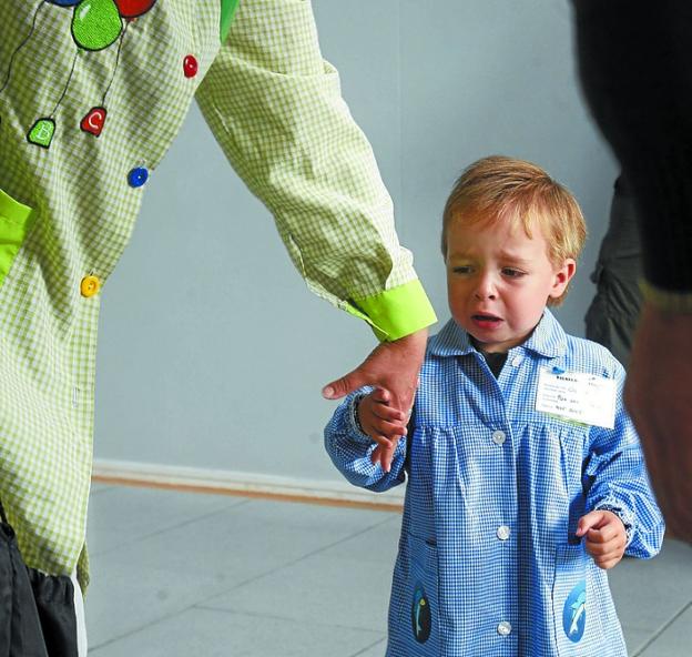 Un niño a la mano a la andereño en su primer día de colegio.
