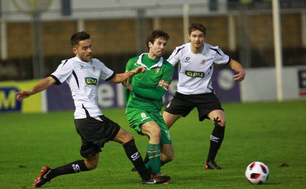 Dani Estrada trata de llevarse el balón ante la oposición del capitán del Gernika.