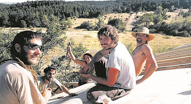 Un grupo de jóvenes trabaja en la reconstrucción de un tejado en la aldea de Fraguas (Guadalajara). 