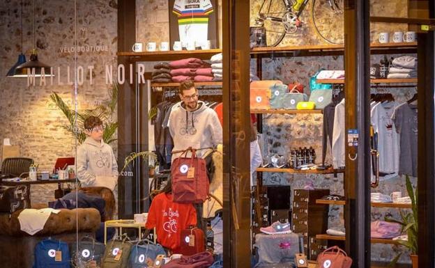 Imagen principal - La tienda en la que se vende la ropa de la marca y tanto Joseba Beloki como Nani Roma con una camiseta de La Bicicleta. 