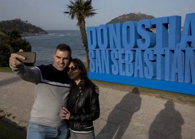 Imagen secundaria 1 - Dos amigas griegas posan sobre el letrero. Debajo, Fernando y Elena se hacen un selfie para el recuerdo.