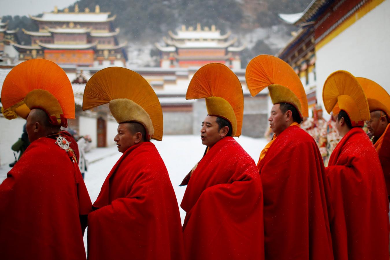 El frío y la nieve no impidió que los monjes tibetanos asistieran a una ceremonia en el Langmu Lamasery durante el 'Sunbathing Buddha Festival', el pasado domingo en la Prefectura Autónoma Tibetana de Gannan, provincia de Gansu, China.