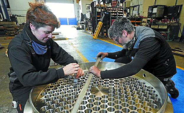 Gemma Marrero y Víctor De Benito manipulan una pieza en la planta productiva de talleres Hadimek, en el polígono industrial de Itziar.