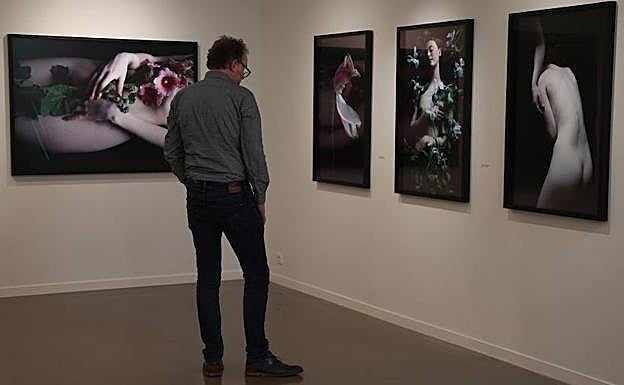 Un visitante ante algunas de las fotografías de Carla Van de Puttelaar.